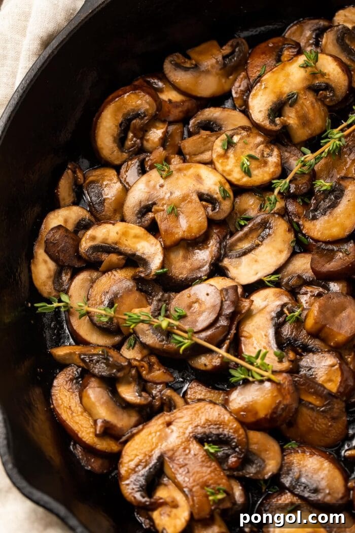 Sizzling sautéed mushrooms in a classic cast iron skillet, golden brown and perfectly cooked.