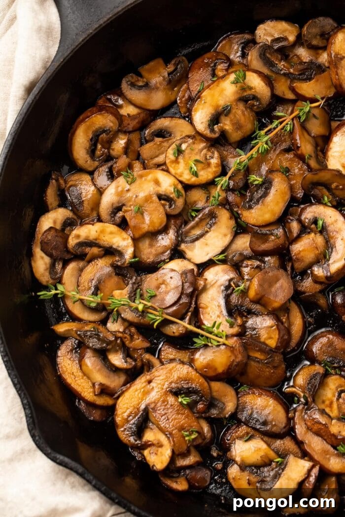 Close-up of perfectly sautéed mushrooms, caramelized and glistening in a cast iron pan.