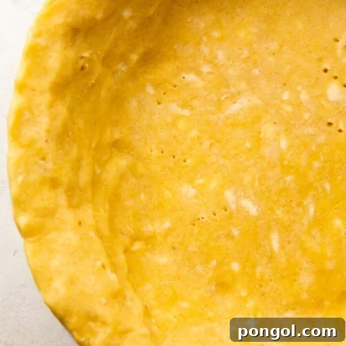 Perfectly Flaky Keto Gluten-Free Low-Carb Pie Crust 4 Overhead view of a baked keto pie crust in a pie dish, golden brown and ready for filling.