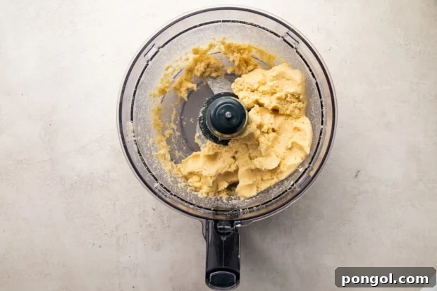 Perfectly Flaky Keto Gluten-Free Low-Carb Pie Crust 6 Keto pie crust dough in food processor resembling moist crumbs.