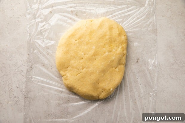 Perfectly Flaky Keto Gluten-Free Low-Carb Pie Crust 7 Ball of keto pie crust dough wrapped in plastic wrap on a counter.