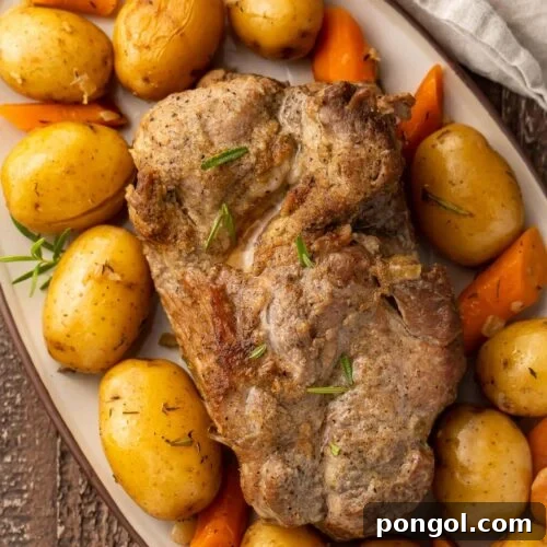 Instant Pot pork roast with carrots and potatoes on a large oval-shaped dish.