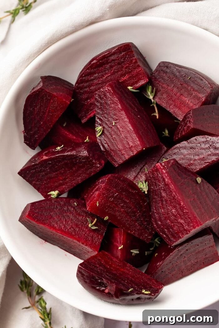 Two hands holding a freshly cooked Instant Pot beet, showing its vibrant color