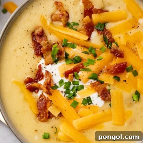 Overhead view of Instant Pot potato soup with shredded cheese and bacon in Instant Pot