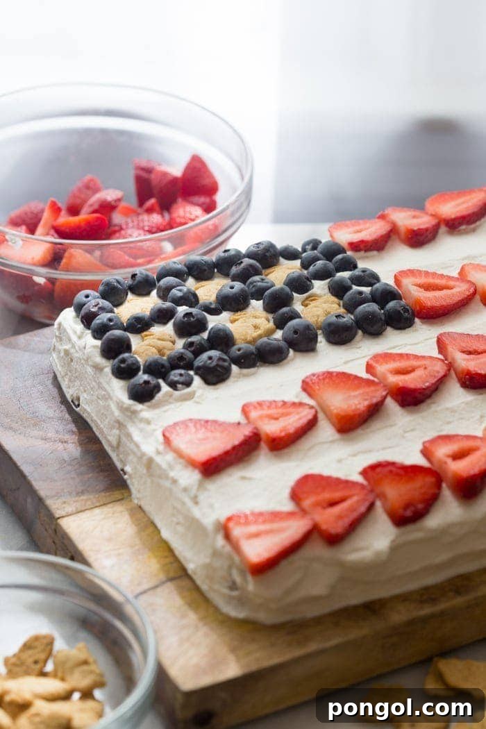 Close-up of flag cake with cream cheese whipped cream, fruit, and Bunny Grahams