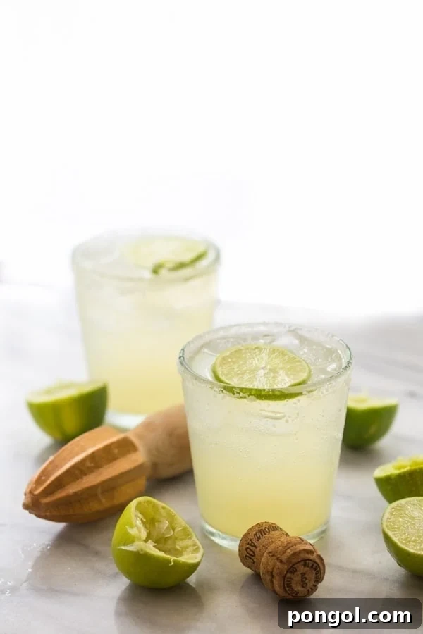 A perfectly balanced Champagne Margarita, garnished with lime and a hint of salt, ready to be enjoyed.