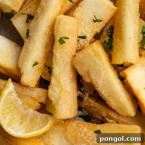 close-up image of yucca fries with a lemon wedge