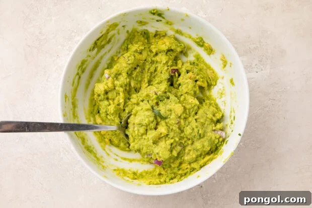 Quick guacamole in small bowl with spoon