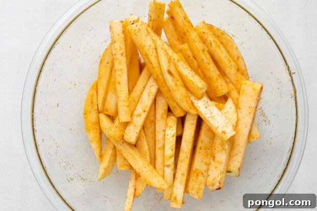 Rutabaga fries coated in spices before baking