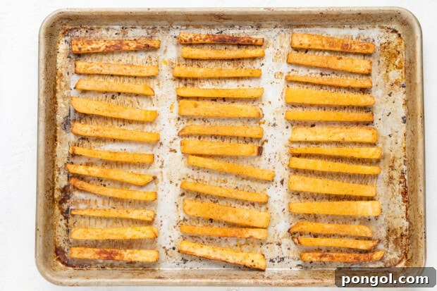 Baked rutabaga fries on a baking sheet
