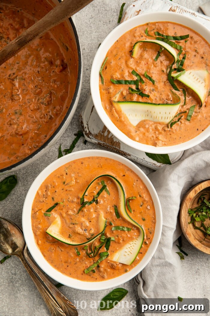 Overhead view of two bowls of Whole30 lasagna soup garnished with fresh basil, showcasing the inviting presentation and vibrant colors.