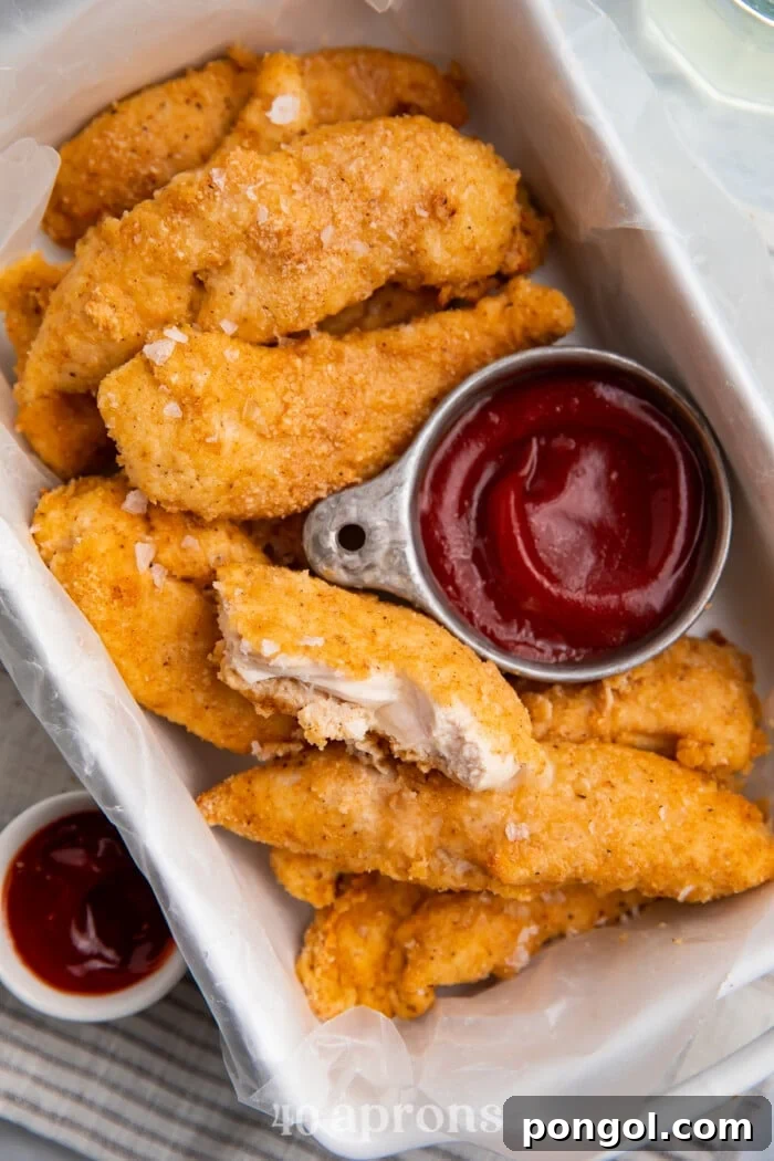 Whole30 chicken tenders in a baking dish with a compliant dipping sauce