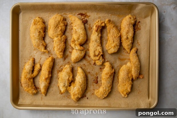 Baked Whole30 chicken tenders fresh out of the oven on a baking sheet