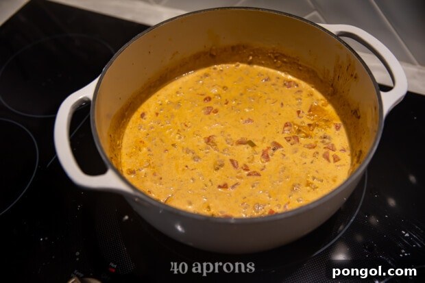 Keto taco soup simmering in a large saucepan, with all ingredients combined.