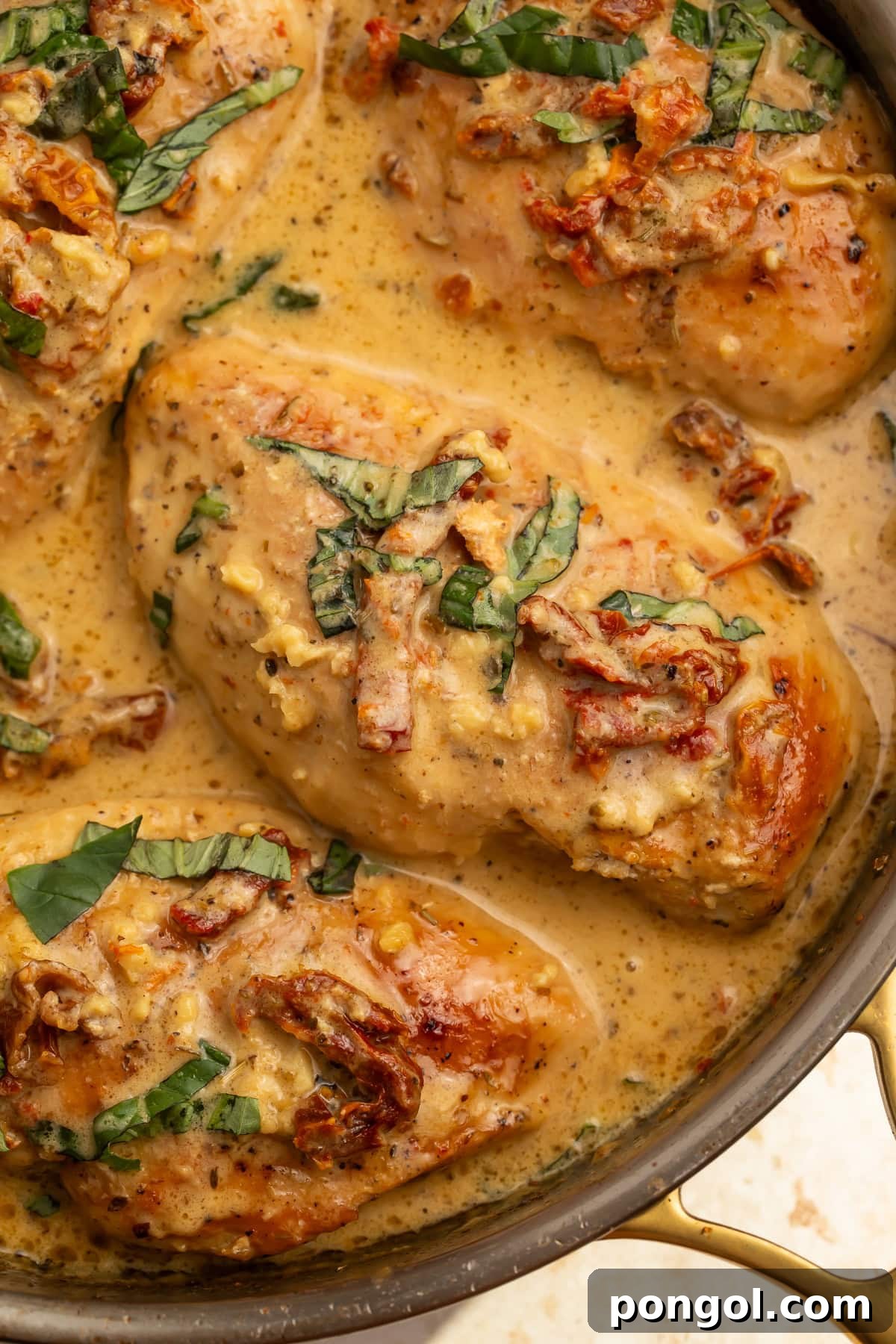 Close up of Whole30 marry me chicken breasts in skillet with creamy sauce and sun-dried tomatoes.