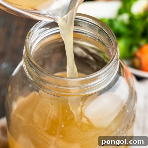 crockpot bone broth being poured into a jar