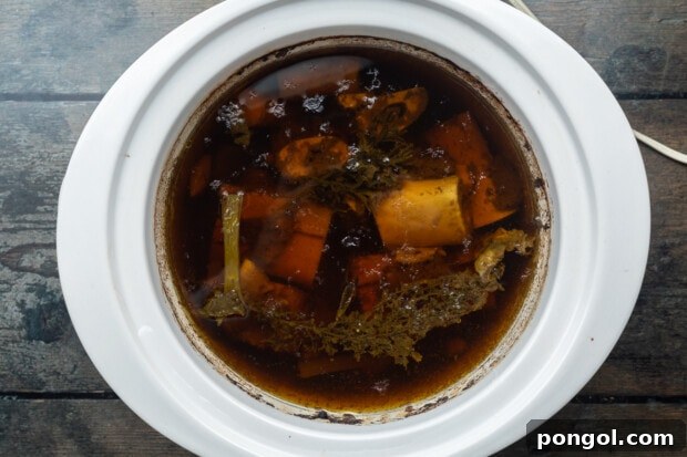 crockpot bone broth step 2 - broth simmering in a slow cooker