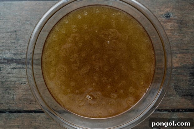 crockpot bone broth step 3 - straining broth into a jar