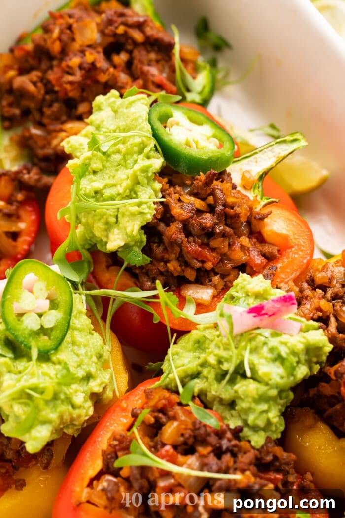 Whole30 Paleo Low Carb Taco Stuffed Peppers 3 Close-up view of Whole30 taco stuffed peppers in a baking dish, highlighting the savory filling and tender peppers.