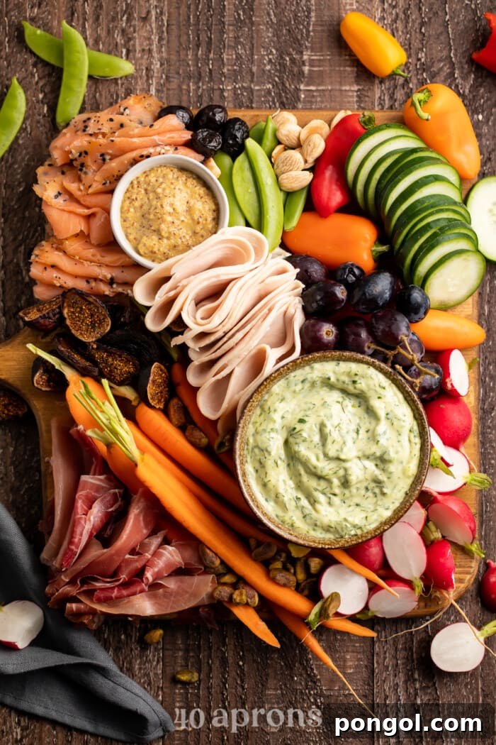 Overhead photo of a Whole30 grazing board, brimming with colorful ingredients like meats, vegetables, fruits, and dips, arranged on a round platter.
