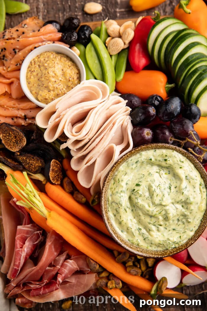 Close-up overhead photo of a Whole30 grazing board, showcasing individual elements like folded prosciutto, fresh berries, sliced bell peppers, and olives.