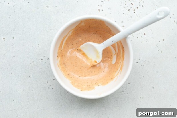 All bloomin' onion sauce ingredients mixed smoothly in a small white bowl, ready to be served.