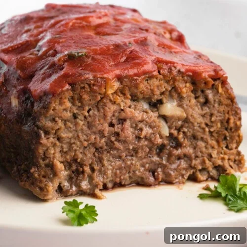 A closeup of a sliced loaf of paleo meatloaf on a plate