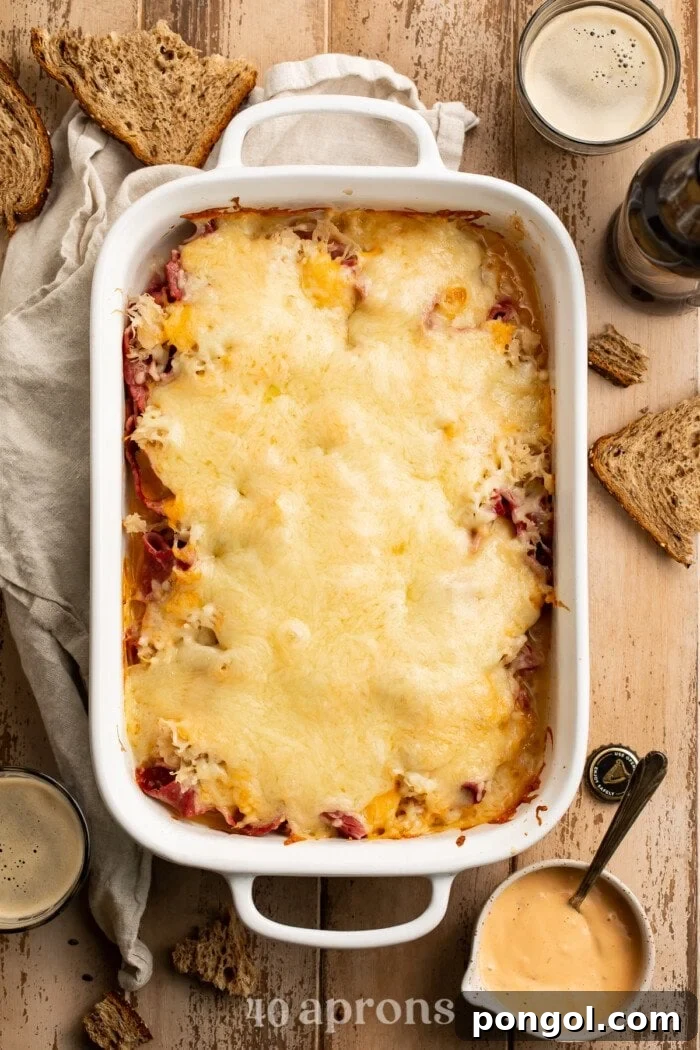 Overhead view of a golden-brown Reuben casserole in a white baking dish, showcasing melted cheese and savory ingredients.