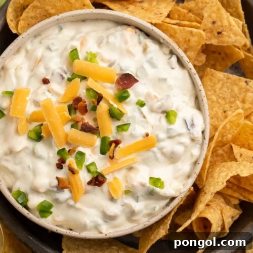Overhead view of a bowl of jalapeno popper dip and tortilla chips.