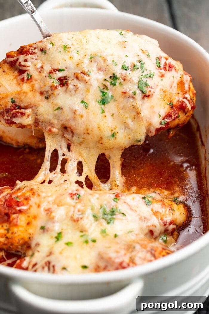 cheesy salsa chicken being lifted out of a baking dish