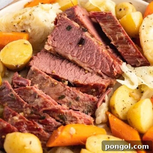 Overhead angled photo of sliced Instant Pot corned beef and cabbage with potatoes and carrots.