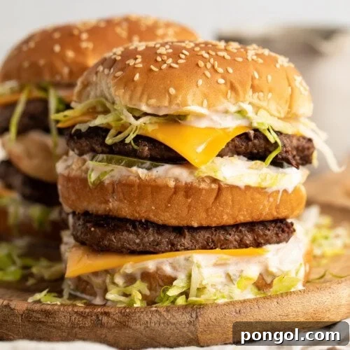 A stack of keto big macs on a wooden cutting board.