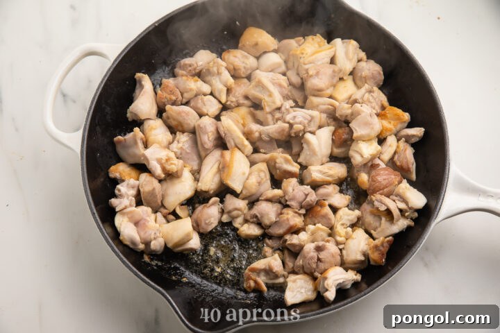 Velvet Butter Chicken 5 Salted chicken thighs cut into bite-sized pieces and piled into a wok to stir fry.