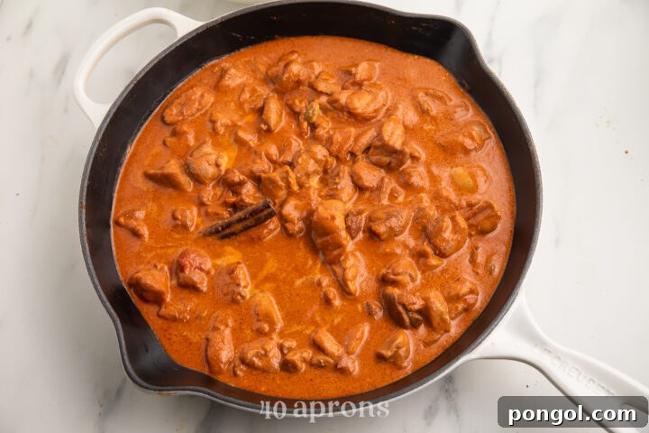 Velvet Butter Chicken 7 Indian butter chicken in a large wok on a neutral background.