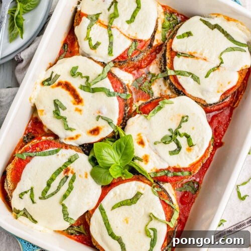 Keto eggplant parmesan in a deep baking dish with turquoise handles.