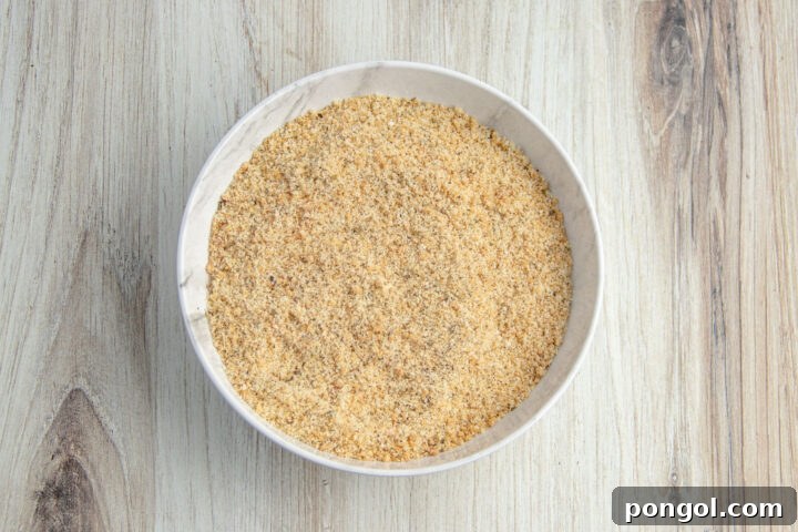 Keto breading mixture in a shallow bowl on a light neutral countertop.