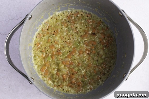 Mirepoix in heavy-bottomed pot on white background.