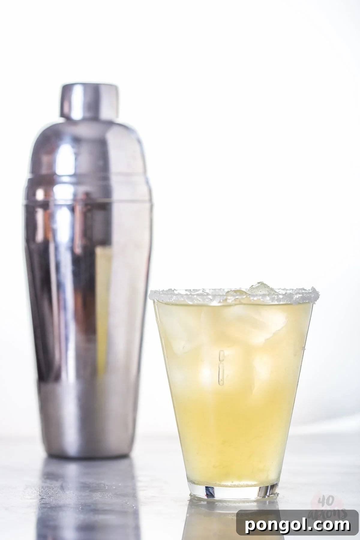 Two healthy margaritas, one with a salt rim, on a rustic wooden surface, showcasing their fresh appeal.