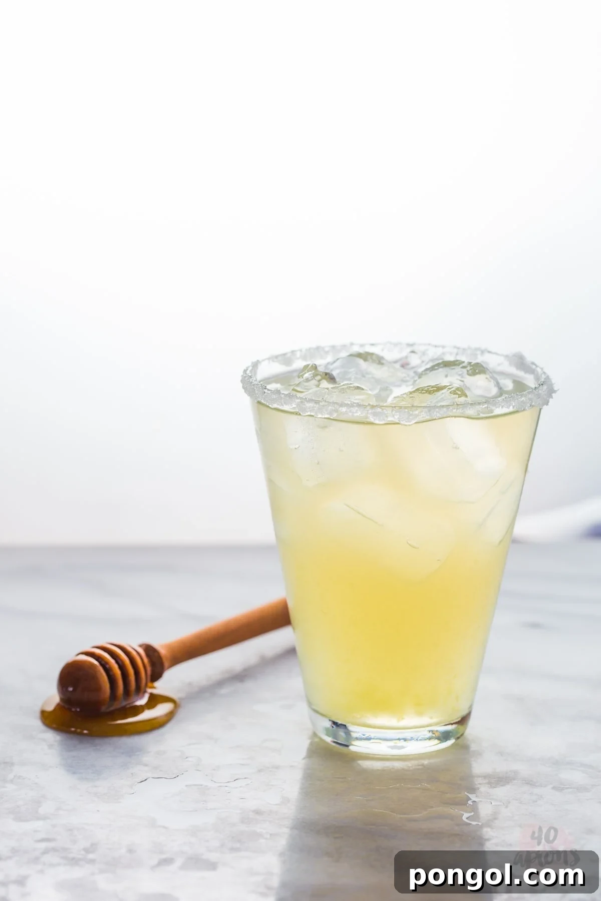 Close-up of a hand adding fresh lime juice to a cocktail shaker for a healthy margarita.