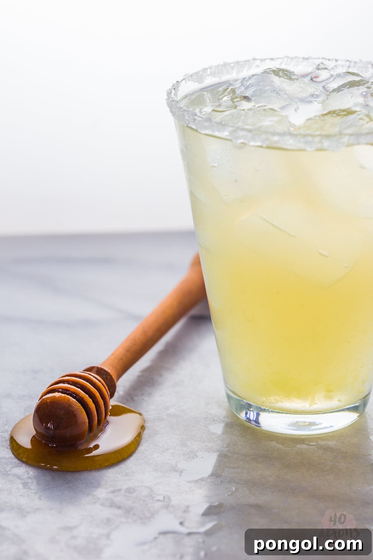Ingredients for a healthy margarita: fresh limes, honey, and a bottle of tequila.