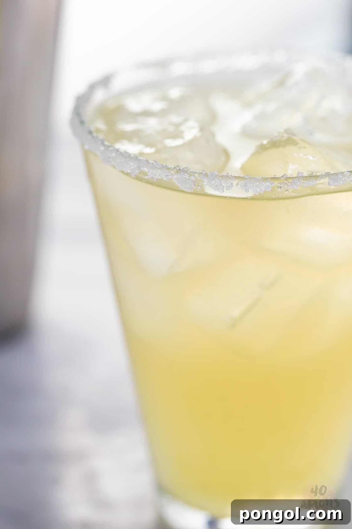 A refreshing healthy margarita ready to be enjoyed, with a blurred background of a cozy setting.