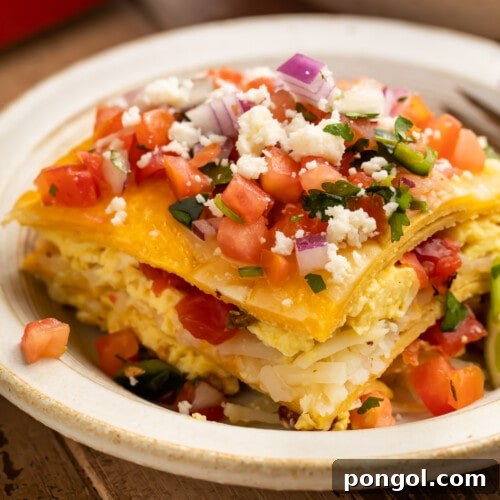 A square slice of breakfast taco casserole on a white plate, showing the layers of tortilla, eggs, and pico.