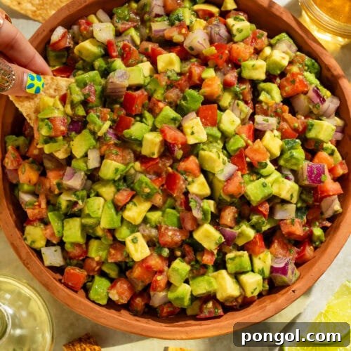 Close-up overhead view of fresh avocado tomato salsa showing colorful diced vegetables