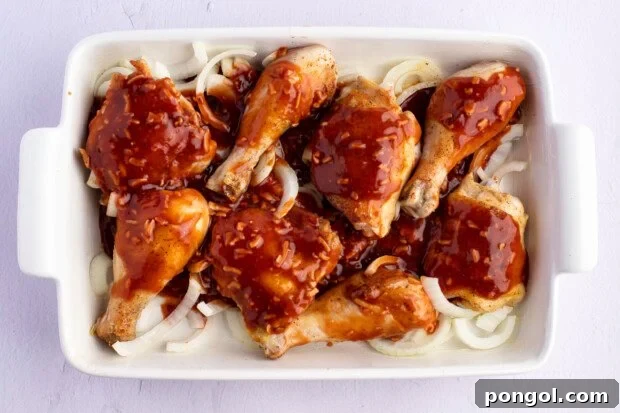 Celebration chicken, unbaked, in 9x13 baking dish after sauce has been added.