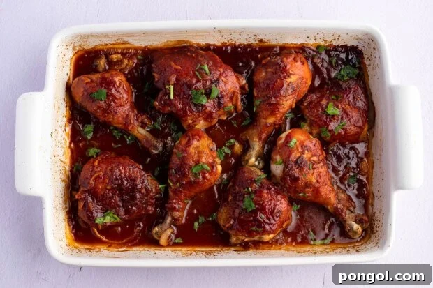 Overhead view of baked celebration chicken in a white 9x13 rectangular baking dish.