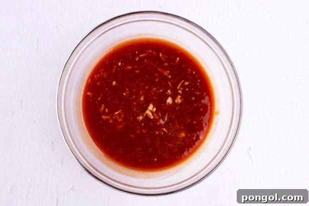 Sauce for celebration chicken in a large glass mixing bowl.