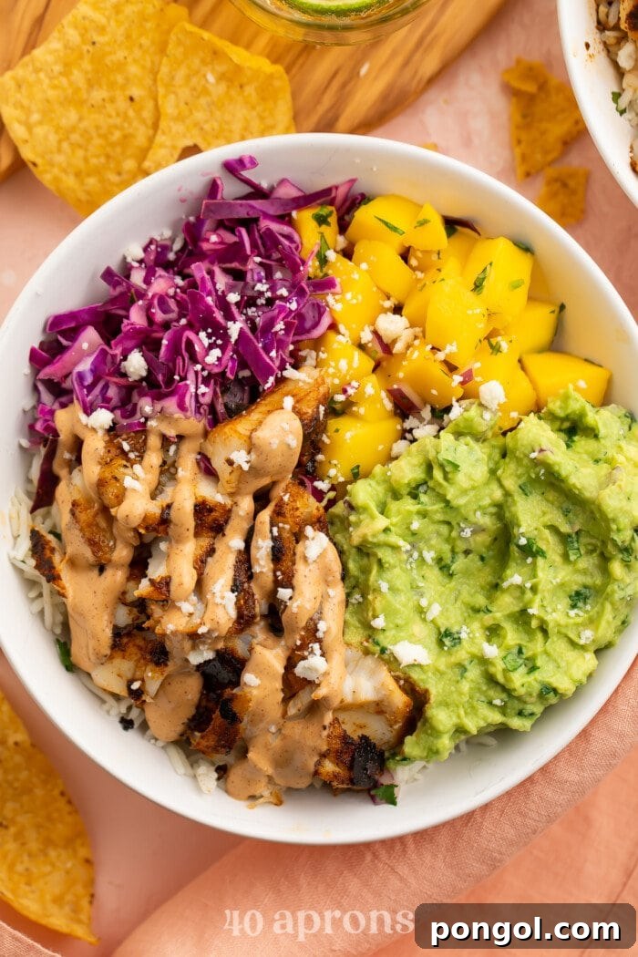 Overhead view of a fish taco bowl with mango salsa and red cabbage slaw.