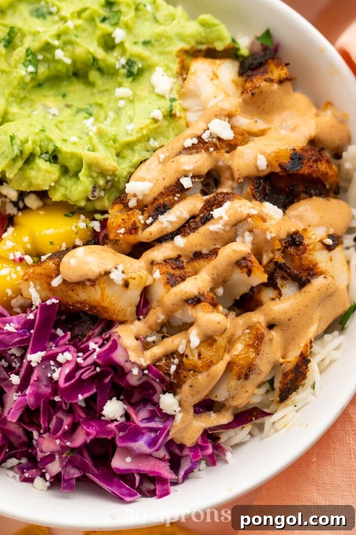 Closeup view of blackened fish taco bowls with gauc and red cabbage slaw.