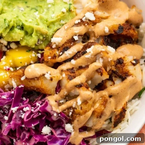 Closeup view of blackened fish taco bowls with gauc and red cabbage slaw.