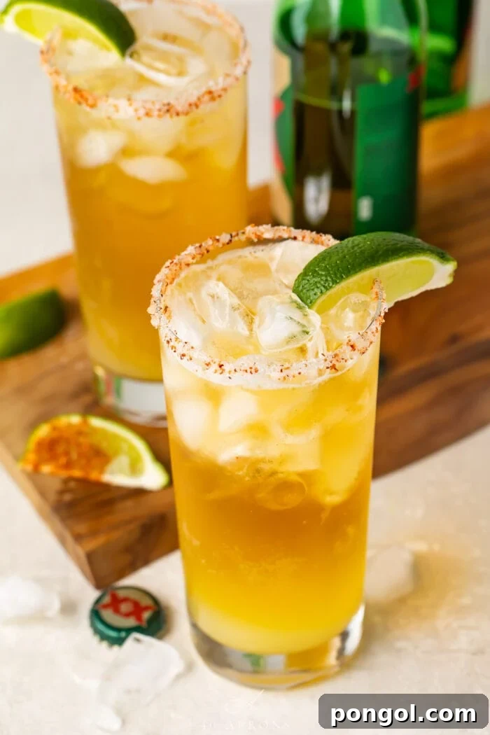 Chelada Zesty Mexican Beer with a Burst of Lime 3 Tall salt-rimmed glass of chelada with lime wedge garnish on a table with a wooden board, ready to be enjoyed.